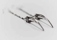 silver claw earrings displayed on white background