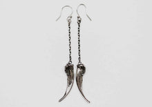 silver claw earrings displayed on a white background