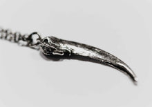 silver badger claw pendant sitting on white background