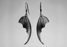 bat wing silver earrings on a light background