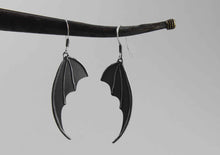 bat wing silver earrings on grey background