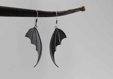 bat wing silver earrings on light background